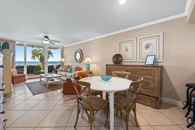 a dining room and living room with a table and chairs at Pelican Walk 110 in Panama City Beach