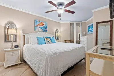 a bedroom with a bed and a ceiling fan at Pelican Walk 110 in Panama City Beach