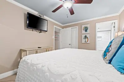 a bedroom with a bed and a flat screen tv at Pelican Walk 110 in Panama City Beach