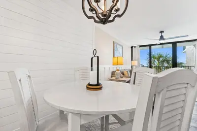 a white dining room with a white table and chairs at Pelican Walk 302 in Panama City Beach