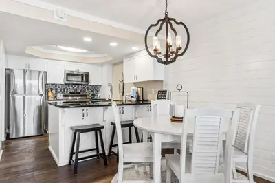 a kitchen and dining room with a table and chairs at Pelican Walk 302 in Panama City Beach