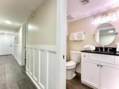 a bathroom with a toilet and a sink and a mirror at Pelican Walk 302 in Panama City Beach