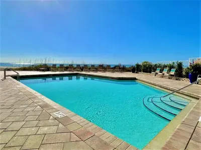 a swimming pool with blue water on a patio at Pelican Walk 302 in Panama City Beach