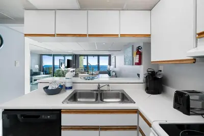 a kitchen with white cabinets and a sink at Pelican Walk 509 in Panama City Beach