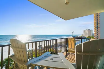 two chairs and a table on a balcony with the ocean at Pelican Walk 509 in Panama City Beach