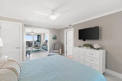 a bedroom with a bed and a flat screen tv at Pelican Walk 405 in Panama City Beach