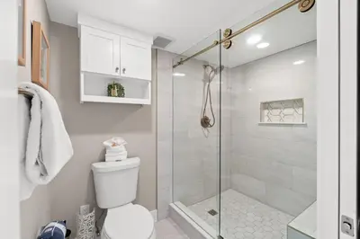 a bathroom with a toilet and a glass shower at Pelican Walk 405 in Panama City Beach