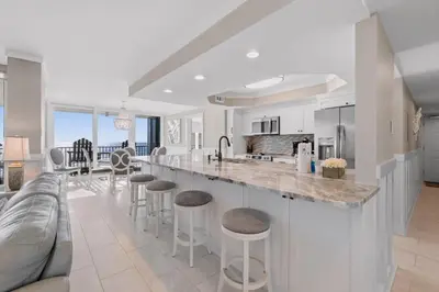 a kitchen and living room with a bar and a couch at Pelican Walk 405 in Panama City Beach