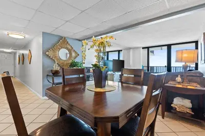 a dining room and living room with a table and chairs at Pelican Walk 710 in Panama City Beach