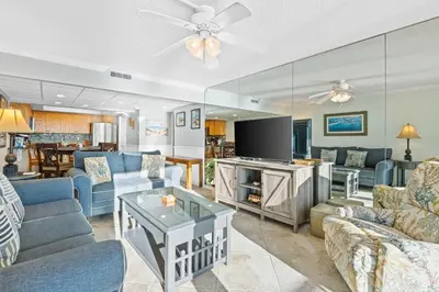 a living room with blue couches and a table at Pelican Walk 610 in Panama City Beach