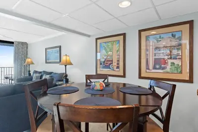 a living room with a table and chairs and a couch at Pelican Walk 610 in Panama City Beach