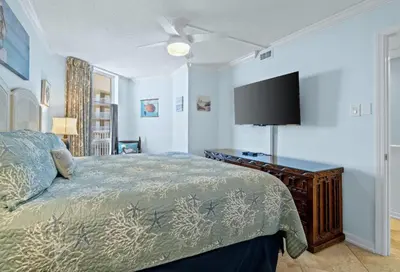 a bedroom with a bed and a flat screen tv at Pelican Walk 610 in Panama City Beach