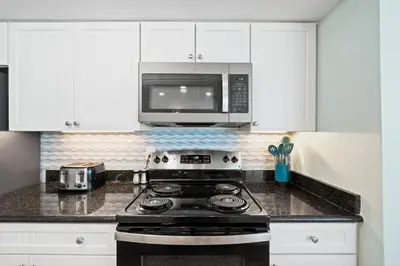 a kitchen with a stove and a microwave at Pelican Walk 812 in Panama City Beach
