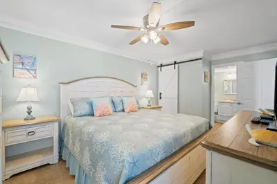 a bedroom with a bed and a ceiling fan at Pelican Walk 812 in Panama City Beach