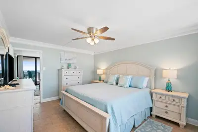 a bedroom with a bed and a ceiling fan at Pelican Walk 812 in Panama City Beach