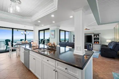 a kitchen and living room with a view of the ocean at Pelican Walk 812 in Panama City Beach