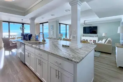 a large kitchen with a large counter and a living room at Pelican Walk 912 in Panama City Beach
