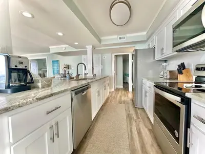 a kitchen with white cabinets and a sink at Pelican Walk 912 in Panama City Beach