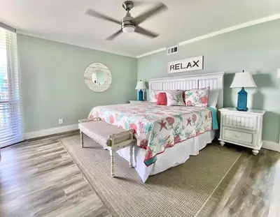 a bedroom with a bed and a ceiling fan at Pelican Walk 912 in Panama City Beach