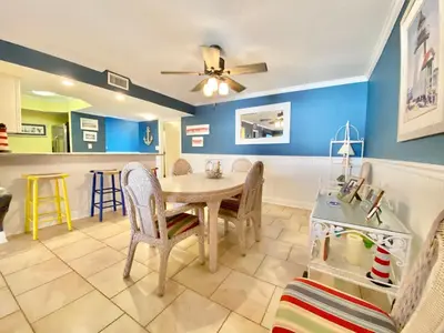 a dining room with blue walls and a table and chairs at Gulfgate 304 in Panama City Beach