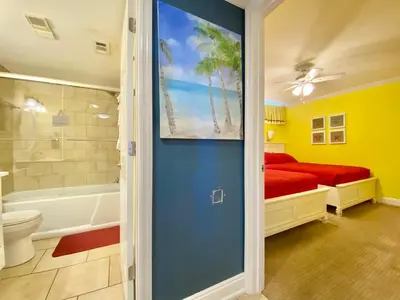 a bathroom with a bed and a bath tub next to a shower at Gulfgate 304 in Panama City Beach
