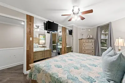 a bedroom with a bed and a ceiling fan at Pelican Walk 104 in Panama City Beach