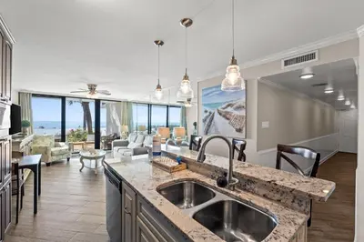 a kitchen and living room with a view of the ocean at Pelican Walk 104 in Panama City Beach