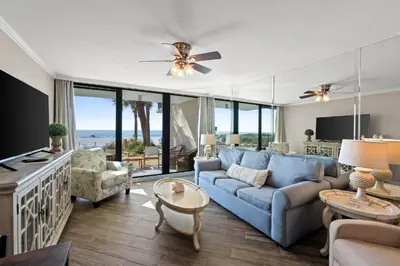 a living room with a blue couch and chairs at Pelican Walk 104 in Panama City Beach
