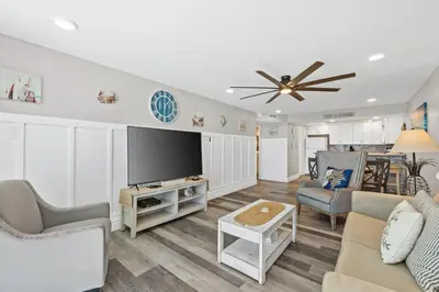 a living room with a flat screen tv and furniture at Pelican Walk 703 in Panama City Beach