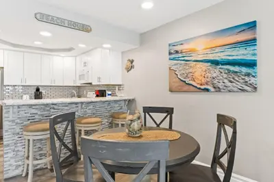a kitchen and dining room with a table and chairs at Pelican Walk 703 in Panama City Beach