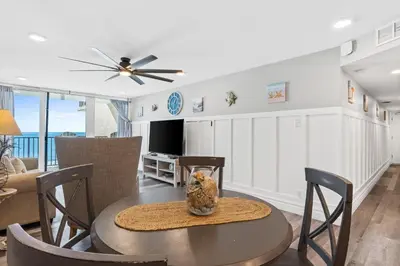 a dining room and living room with a table and chairs at Pelican Walk 703 in Panama City Beach