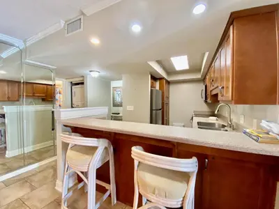 a kitchen with a counter and two stools at Gulfgate 311 in Panama City Beach