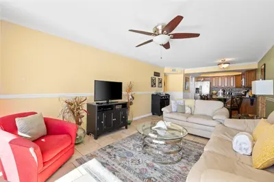 a living room with couches and a ceiling fan at Pelican Walk 802 in Panama City Beach