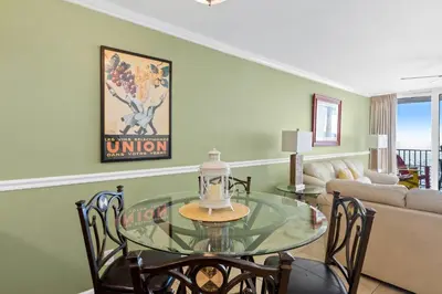 a dining room with a glass table and chairs at Pelican Walk 802 in Panama City Beach