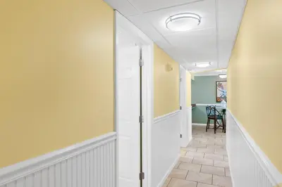 a hallway with yellow walls and a door at Pelican Walk 802 in Panama City Beach