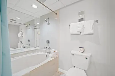 a white bathroom with a tub and a toilet at Pelican Walk 706 in Panama City Beach