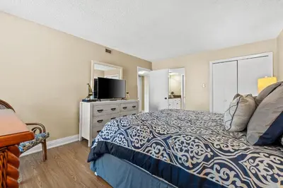 a bedroom with a bed and a flat screen tv at Pelican Walk 806 in Panama City Beach