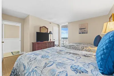 a bedroom with two beds and a flat screen tv at Pelican Walk 806 in Panama City Beach