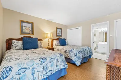 a bedroom with two beds with blue and white sheets at Pelican Walk 806 in Panama City Beach