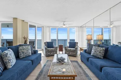 a living room with blue couches and windows at Pelican Walk 806 in Panama City Beach