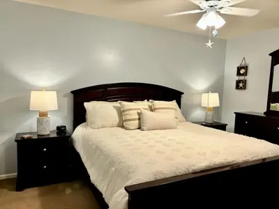 a bedroom with a large bed with a ceiling fan at Cozy Beach Condo in Complex in Panama City Beach
