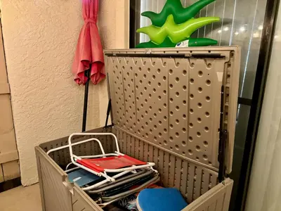 a metal shelf with a rack with towels and a umbrella at Cozy Beach Condo in Complex in Panama City Beach
