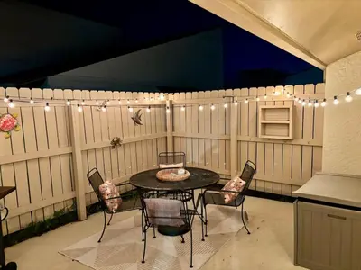a patio with a table and chairs and lights at Cozy Beach Condo in Complex in Panama City Beach
