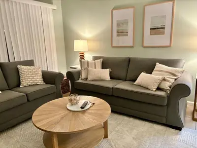 a living room with a couch and a table at Cozy Beach Condo in Complex in Panama City Beach