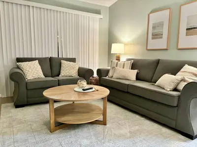 a living room with a couch and a table at Cozy Beach Condo in Complex in Panama City Beach