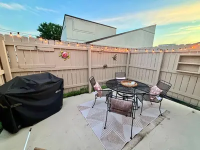 a patio with a table and chairs and a fence at Cozy Beach Condo in Complex in Panama City Beach