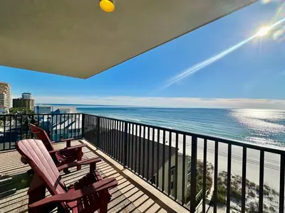 a balcony with two chairs and a view of the ocean at Pelican Walk 801 in Panama City Beach