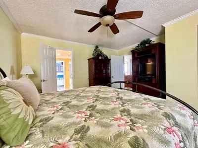 a bedroom with a bed with a ceiling fan at Pelican Walk 801 in Panama City Beach