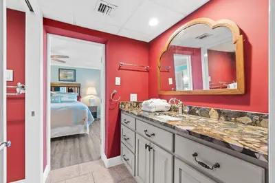 a bathroom with a sink and a mirror and a bed at Pelican Walk 212 in Panama City Beach