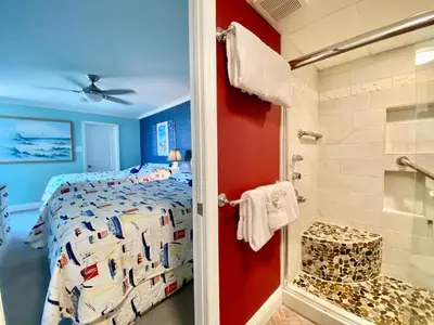 a bedroom with a bed and a shower at Pelican Walk 212 in Panama City Beach